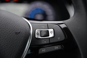 Close up of car's steering wheel controls Buttons for audio phone and vehicle functions photo