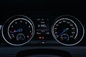 Close up view of a car's instrument panel showing the speedometer tachometer and fuel gauge photo