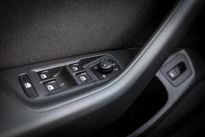 Close up of car door panel with power window and mirror controls photo