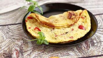 fried omelette with sweet pepper and vegetables in a plate on a wooden table video