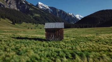 Scenic Mountain Landscape Footage Capturing a Rustic Cabin in Green Meadow video