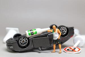A Drunk driver holding a liquor bottle as he steps out of a car. concepts of reckless behavior urban life photo