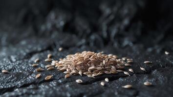 Flax seeds scattered on a dark textured surfaceFlax seeds scattered on a dark textured surface. photo