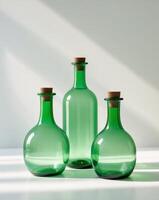 three green bottles with corks on a white surface photo