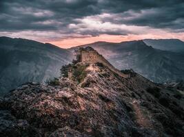 Dramatic view at the ancient fortress on the top of the mountain. The Gunib fortress is a historical monument of Dagestan. Russia. photo
