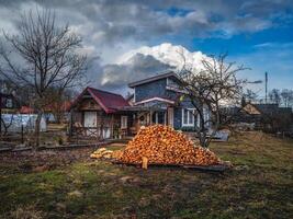 Farm house with firewood in early spring. photo