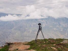 Tripod with a camera over a cliff. Performing a long exposure. photo