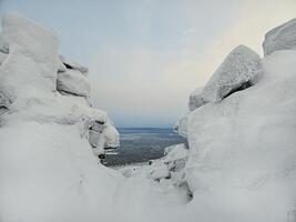 Dangerous winter gorge, a cliff between two snow rocks. photo