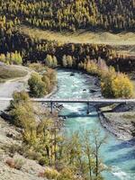 Vertical view to the bridge over the Chuya River. Mountain river on a background of autumn forest. photo