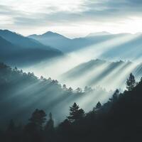 Misty mountain landscape with sun rays illuminating the forest at dawn in a serene natural setting photo