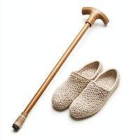 Cozy slippers and a wooden cane placed together on a simple background showcasing comfort and support photo