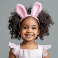 Joyful child wearing bunny ears celebrates with a bright smile in a playful setting photo