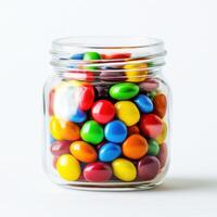 Colorful candy jar filled with assorted treats on a light background photo