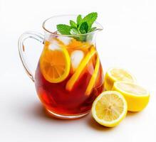 Refreshing iced tea with lemon and mint served in a clear pitcher alongside fresh lemon slices photo
