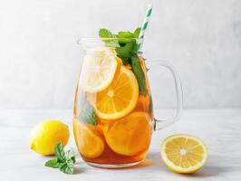 Refreshing lemonade with mint leaves served in a pitcher on a light background photo