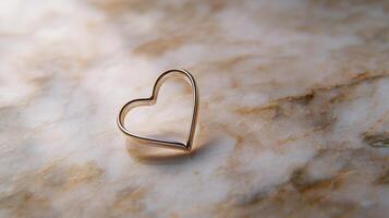 Solitary paperclip bent into a heart shape resting on white marble soft shadows and modern minimalist concept photo
