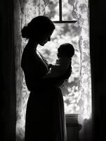 Black and white portrait of mother tenderly holding her newborn wrapped in a blanket soft home lighting photo