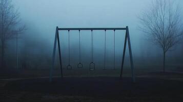 Atmospheric photography of a foggy deserted playground with empty swings in a mysterious misty setting photo