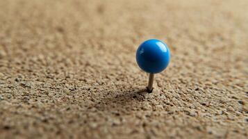 Single blue pushpin inserted into a textured corkboard warm natural lighting photo