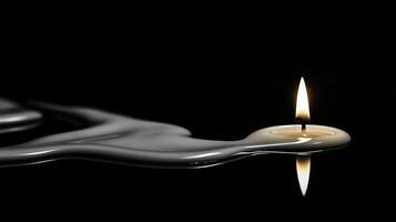 Artistic display of a single white candle melting onto reflective surface in dramatic low light photo