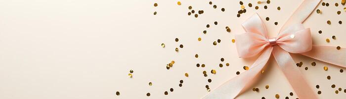 This festive background features scattered gold confetti and a delightful pink ribbon bow, set against a smooth light beige surface, perfect for celebrations and special occasions photo