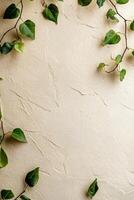Soft textured beige surface features fresh green leaves scattered along the edges, creating an eco-friendly atmosphere with ample space for text overlay and creative designs photo
