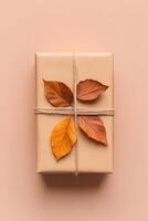 This unique gift box, made from recycled paper, features a charming decoration of dried autumn leaves and is tied with a thin cotton string, perfect for eco-conscious gifting photo