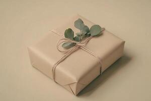 A carefully wrapped gift box showcases minimalist Nordic design, featuring beige kraft paper, natural twine, and a sprig of eucalyptus, set against a clean light background photo