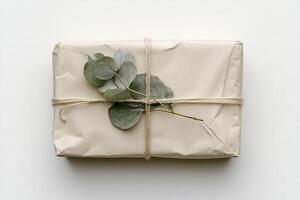 This calming gift box features minimalist Nordic design, wrapped in beige kraft paper with twine, topped with a sprig of eucalyptus, creating a warm and organic presentation photo