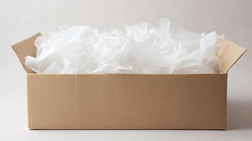 A cardboard box, empty and filled with white tissue paper photo