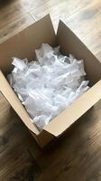 Empty Cardboard Box Filled with White Packing Paper photo
