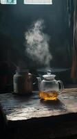 Warm Tea in a Vintage Glass Kettle on Rustic Wooden Table photo