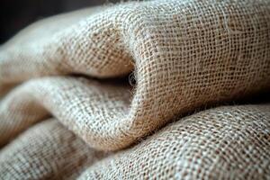 Detailed depiction of rough burlap fabric highlighting its earthy beige color and coarse weave. texture features uneven threads enhance its rustic charm photo