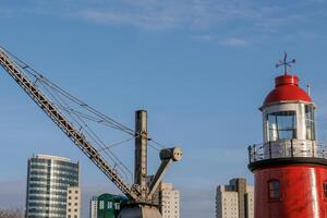 A large crane iand a lighthouse in rotterdam photo