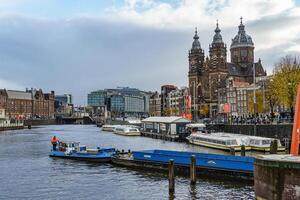 A large building with a clock tower in amsterdam photo