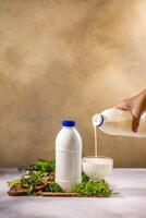 Chef pouring kefir into glass with bread and herbs on table photo