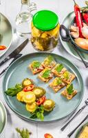 Pickled pattypan squash and canape with pate on festive table setting photo