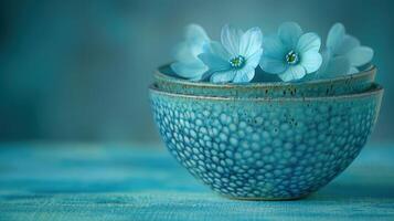 Blue flowers resting in a ceramic bowl photo
