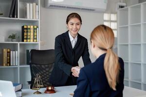 Lawyer shaking hands with a client after a successful contract discussion in a professional office photo