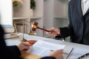 Lawyer discussing a contract with a client while demonstrating authority with a gavel in a professional setting photo