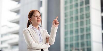 Inspiring businesswoman gesturing with a smile in front of a modern office building photo
