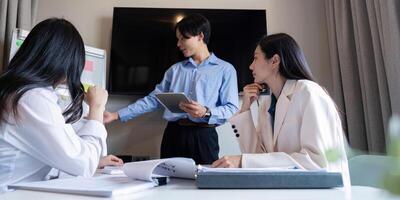 Diverse professionals collaborating during a brainstorming session with digital tablet in modern office photo