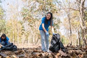 Volunteers smiling while collecting garbage in a forest, highlighting community service and environmental care photo