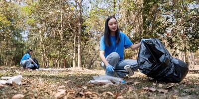 Volunteer collecting trash in a forest, emphasizing environmental responsibility and community service photo