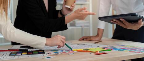 Dynamic UX UI team discussing design strategies while reviewing concepts on a tablet in a modern office photo