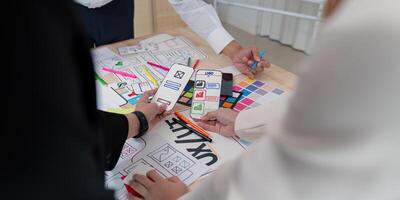 Dynamic UX UI team reviewing mobile app wireframes and sketches during a collaborative design session photo