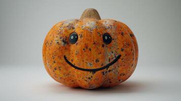 A cheerful pumpkin with a painted smile showcases autumn's playful spirit photo