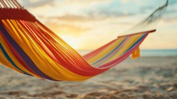 vibrant hammock with colorful stripes sways gently on beach, inviting relaxation as sun sets over horizon, creating serene atmosphere photo
