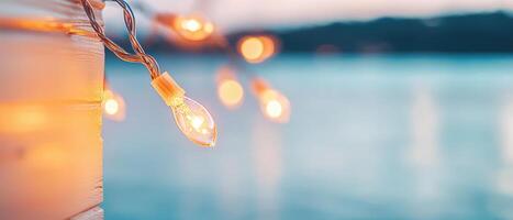 String lights illuminate serene waterfront scene, creating warm and inviting atmosphere perfect for gatherings and celebrations. soft glow enhances tranquil setting photo