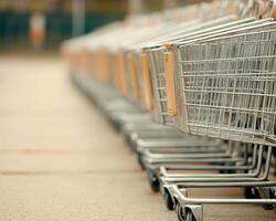 Shopping carts lined up outside supermarket create geometric pattern, showcasing their metallic structure and functional design. scene evokes sense of order and readiness for shopping photo